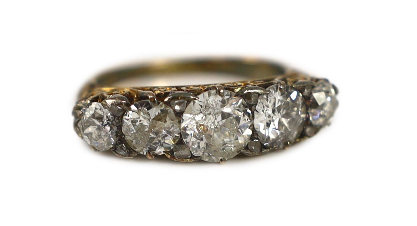 An early 20th century 18ct gold and graduated five stone diamond set half hoop ring